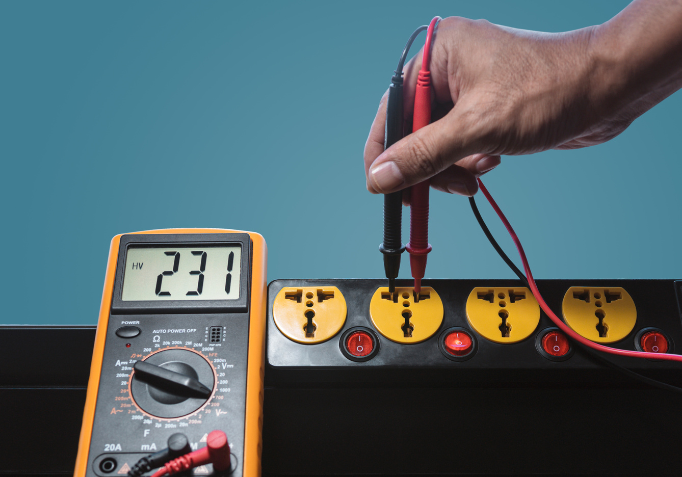 Hand Measuring the Voltage of Power Outlet Using Voltmeter 